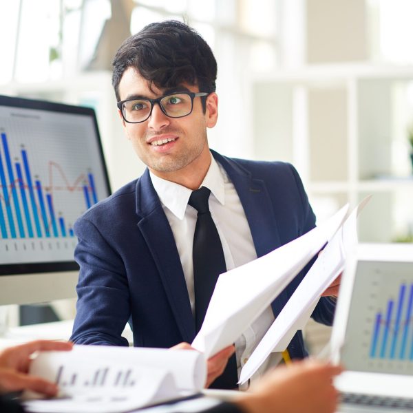 Successful financier showing some papers to co-worker during discussion